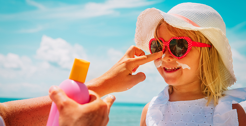 sun protection - mother put sunblock cream on little daughter face